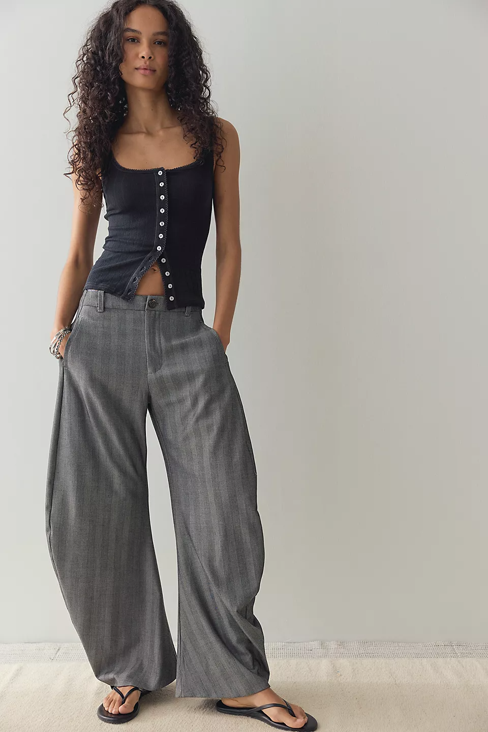 Woman wearing the Black End Game Pointelle Tank with wide-leg gray trousers